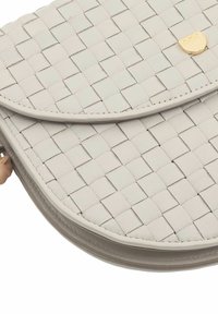 Borsa in pelle grigia intrecciata con flap arrotondato e un sottile logo dorato. Presenta una finitura testurizzata e una chiusura con zip.