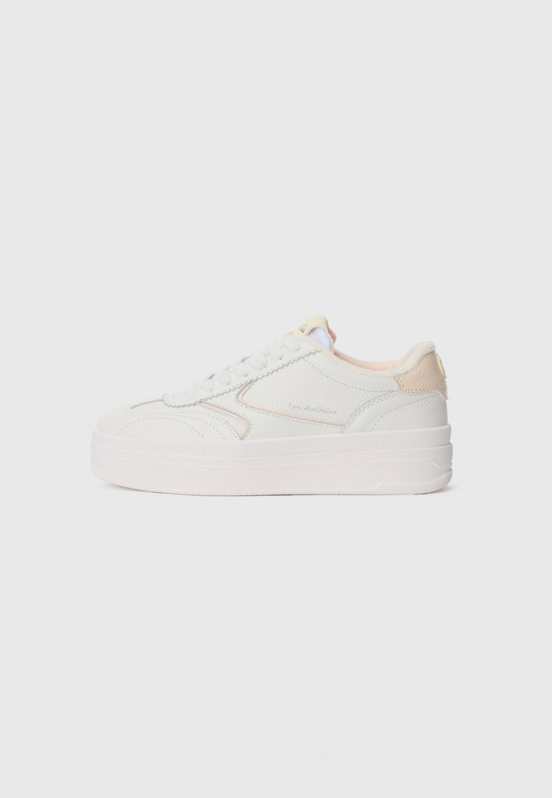 Weiße Leder-Low-Top-Sneaker mit beigen Akzenten, dicker Sohle und Schnürverschluss, von der Seite auf einem schlichten Hintergrund gezeigt.