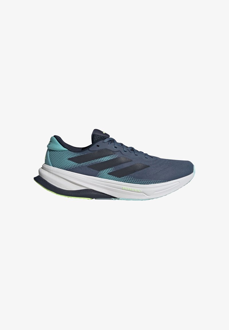 Chaussure de sport bleue avec tige en maille, rayures noires, semelle intermédiaire blanche et talon texturé. Présente des accents verts sur la semelle extérieure.