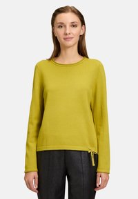 Maglione verde lime con scollatura rotonda, maniche lunghe e dettaglio con fiocco all'orlo. Realizzato in un tessuto morbido e testurizzato.