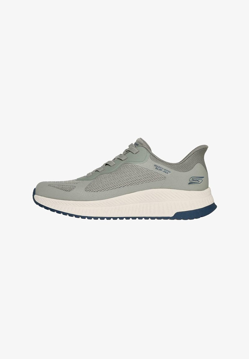 Light gray athletic shoe with a textured mesh upper, lace closure, and a contrasting white and navy sole. Features subtle branding on the side.