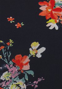 Tissu noir avec un motif floral comprenant des fleurs rouges, jaunes et roses, accompagnées de feuilles vertes. La texture semble douce et lisse.