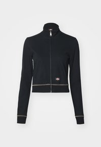 Μαύρο μπουφάν με φερμουάρ και ψηλό γιακά, παρουσιάζοντας δύο πλαϊνές τσέπες, αντίθετη ραφή και μια μικρή ετικέτα λογότυπου στο στρίφωμα.