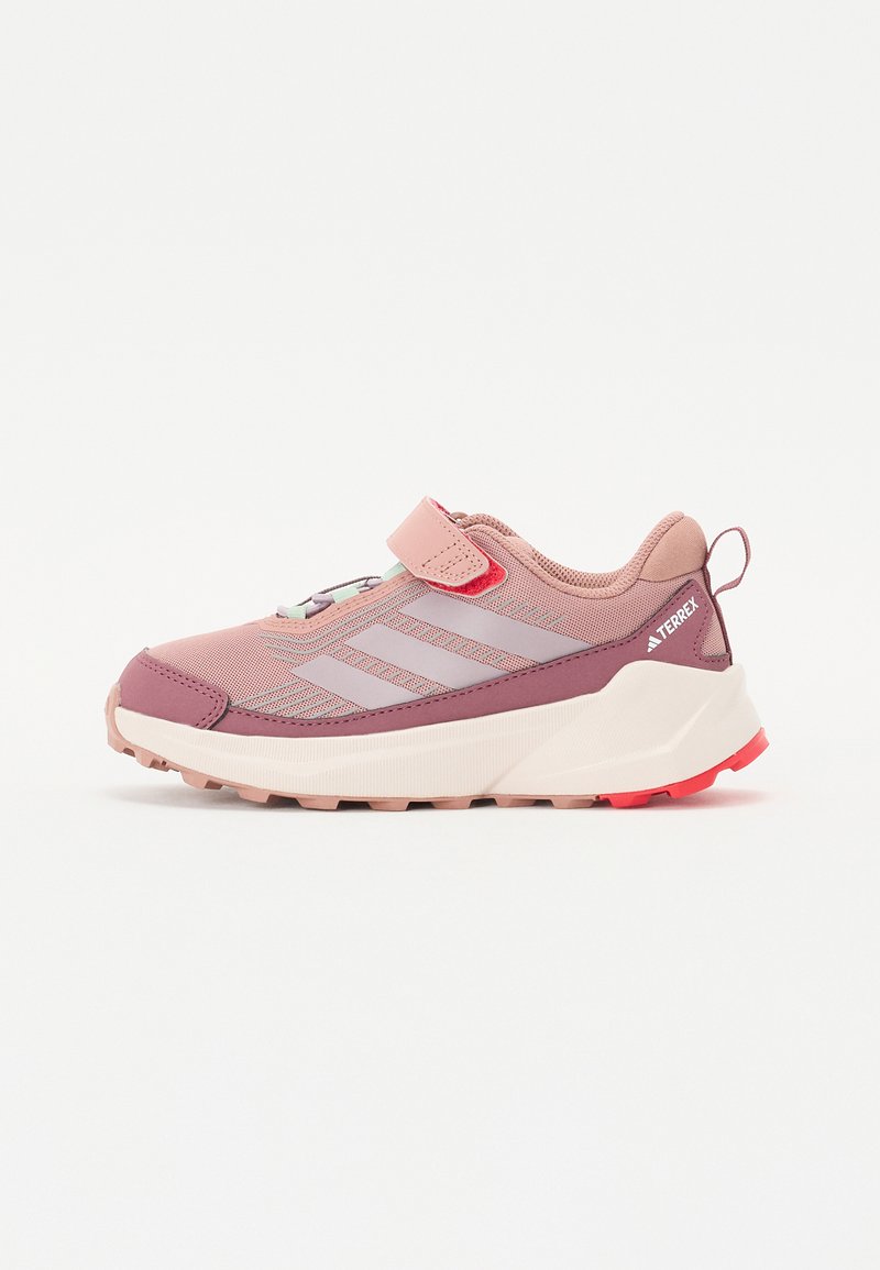 Pink and purple athletic shoe with mesh upper, Velcro strap, textured rubber sole, and triangular tread for grip.