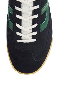 Marineblaues Wildleder-Sneaker mit grünen Lederakzenten, flachen weißen Schnürsenkeln und einer hellbraunen Gummisohle. Verfügt über gestickte Details und ein abgerundetes Zehendesign.