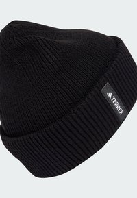 Black knit beanie hat with ribbed texture. Features a folded cuff and a small rectangular tag with "TERREX" logo.