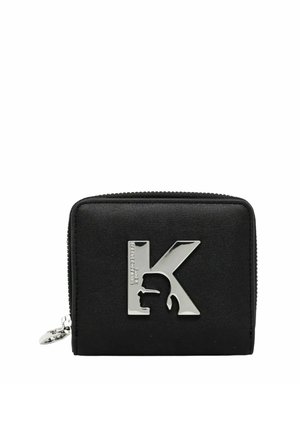 Portafoglio nero con zip con lettera K in metallo argento che presenta una silhouette di profilo sul davanti.