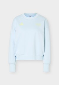Sweat-shirt Adidas bleu clair avec manches longues, poignets côtelés et petit logo jaune Adidas avec texte sur la poitrine.