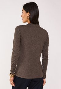 Maglietta a maniche lunghe marrone in tessuto morbido, con scollatura rotonda e design aderente; texture liscia con un sottile motivo melangiato.