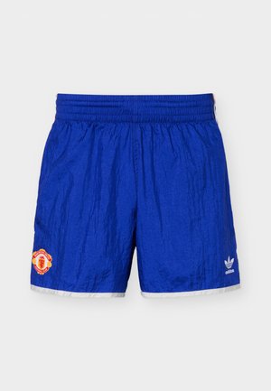 Pantalones cortos deportivos azules con cintura elástica, logo del Manchester United en la pierna izquierda, y logo de Adidas en la pierna derecha, ribete blanco en el dobladillo.