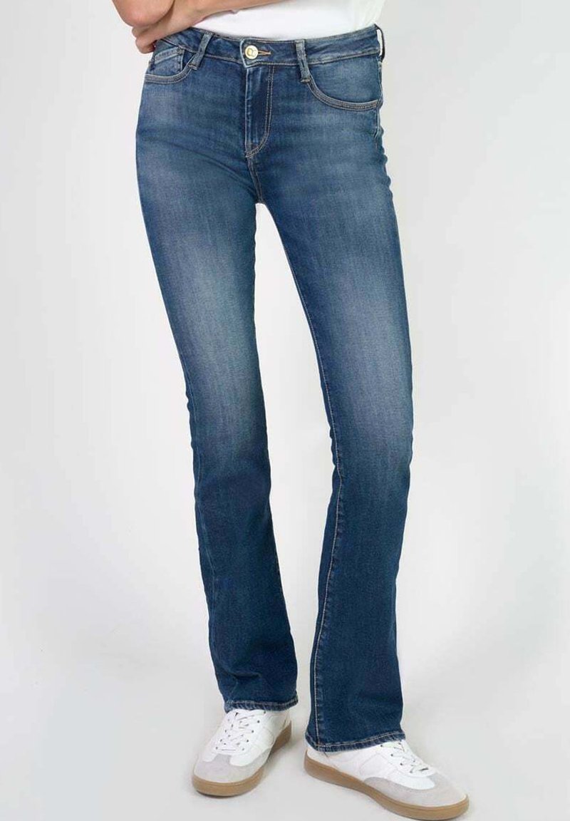 Vervaagde blauwe denim jeans met een rechte snit, vijf zakken, gouden knoopdetails en subtiele stikdetails. Gestyled met witte sneakers.