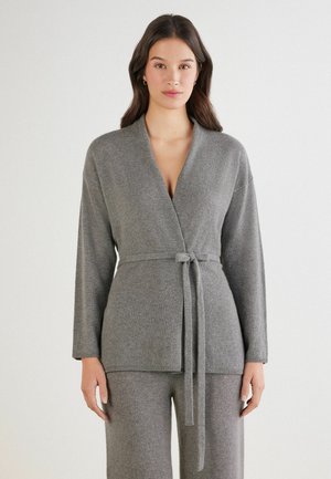 Cardigan enveloppant en tricot gris, fabriqué en matériau doux, avec une ceinture à la taille, des manches longues et un décolleté en V.