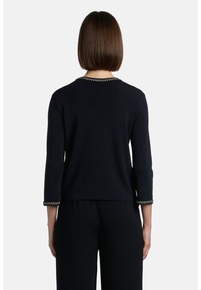 Pulover negru din tricot cu mâneci trei sferturi, având o broderie decorativă cu fir de lanț în jurul gâtului și la marginile manșetelor. Croi clasic.