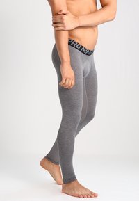 Graue Kompressionsleggings aus dehnbarem Material, mit einem schwarzen "PRO NIKE"-Bund und einem glatten, körpernahen Design.
