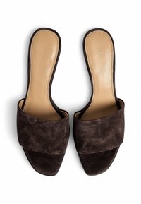 Sandales slip-on en suède marron avec un large design de bande croisée et une semelle intérieure beige lisse. Présente un bout carré et une semelle plate.