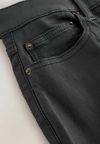 Jeans negri cu un design elegant, textură netedă, cusături proeminente și accente metalice pe buzunare.