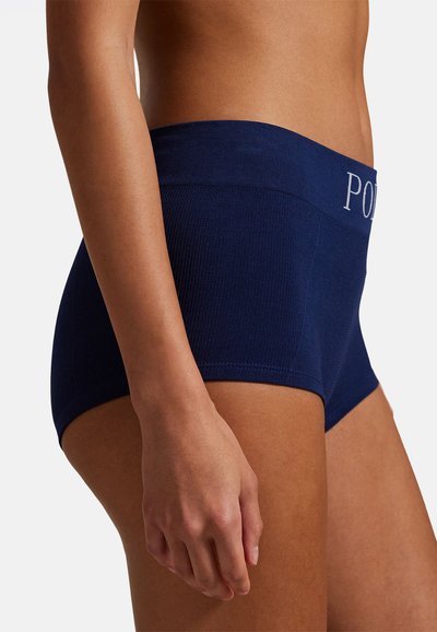 Boxer blu navy in tessuto costine, con una fascia larga in vita ricamata con la scritta "POLD" in grigio chiaro. Texture liscia, design aderente.