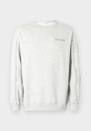 Hanorac gri deschis cu cusături laterale cu fermoar, gât rotund și manșete striate. Prezintă inscripția "UR TRN" imprimată în albastru deschis pe partea din față.