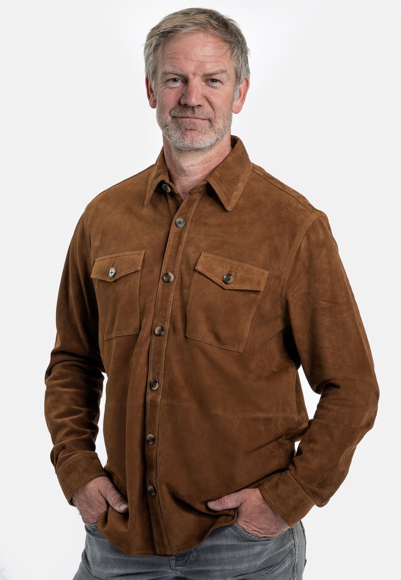 Braunes Wildlederhemd mit Kragen, durchgehender Knopfverschluss, zwei Brusttaschen und einer weichen Textur. Lässiges Design mit langen Ärmeln.