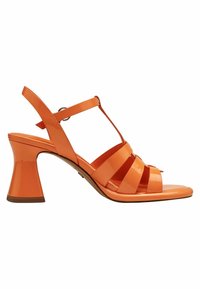 Orange patent leather sandal with a chunky sculpted heel, open-toe design, and crisscross straps. Features an adjustable ankle strap.