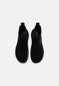 Paire de bottines noires en cuir suédé à enfiler avec des panneaux élastiques sur les côtés et des languettes d'extraction, vues de dessus sur un fond blanc.