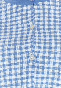 Tissu tricoté à carreaux bleus et blancs avec deux boutons blancs au centre.