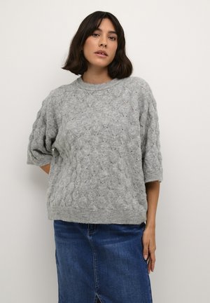 Pulover gri din tricot, cu un model texturat de cabluri, mâneci scurte și decolteu rotund, asortat cu o fustă din denim.