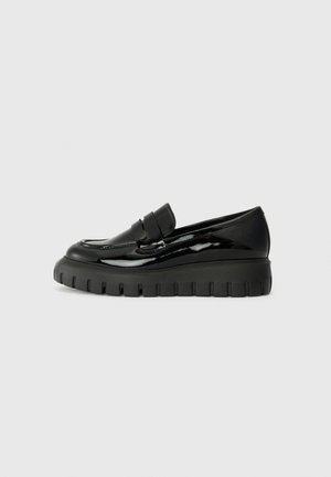 Mocassins en cuir verni noir avec une semelle en caoutchouc noir épaisse et des détails cousus sur le dessus. Design élégant, sans matériel visible.
