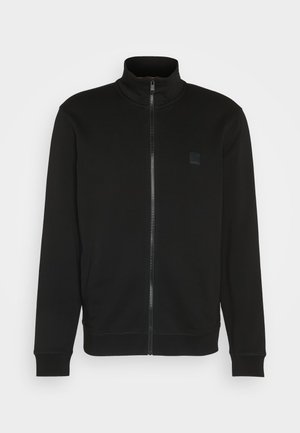 Black zip-up jacket with high collar, made of smooth fabric. Features a small logo patch on the chest and ribbed cuffs and hem for a fitted look.