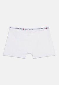 Λευκά βαμβακερά μποξεράκια με το λογότυπο Tommy Hilfiger στη μέση και σήμα με τη σημαία σε κόκκινο, λευκό και μπλε στο κέντρο.