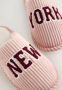 Weiche rosa Cordschuhe mit burgunderfarbenen Buchstaben, die "NEW YORK" darauf buchstabieren, und einem weißen Fleecefutter im Inneren.