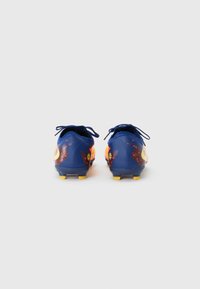 Blue soccer cleats with yellow accents, featuring a textured design and black laces. Vibrant orange and red patterns on the sides.