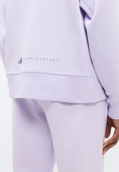 Fialová mikina z mäkkého bavlneného zmesi, s zaobleným lemom, nenápadným sivým logom a rebrovanými manžetami a výstrihom.