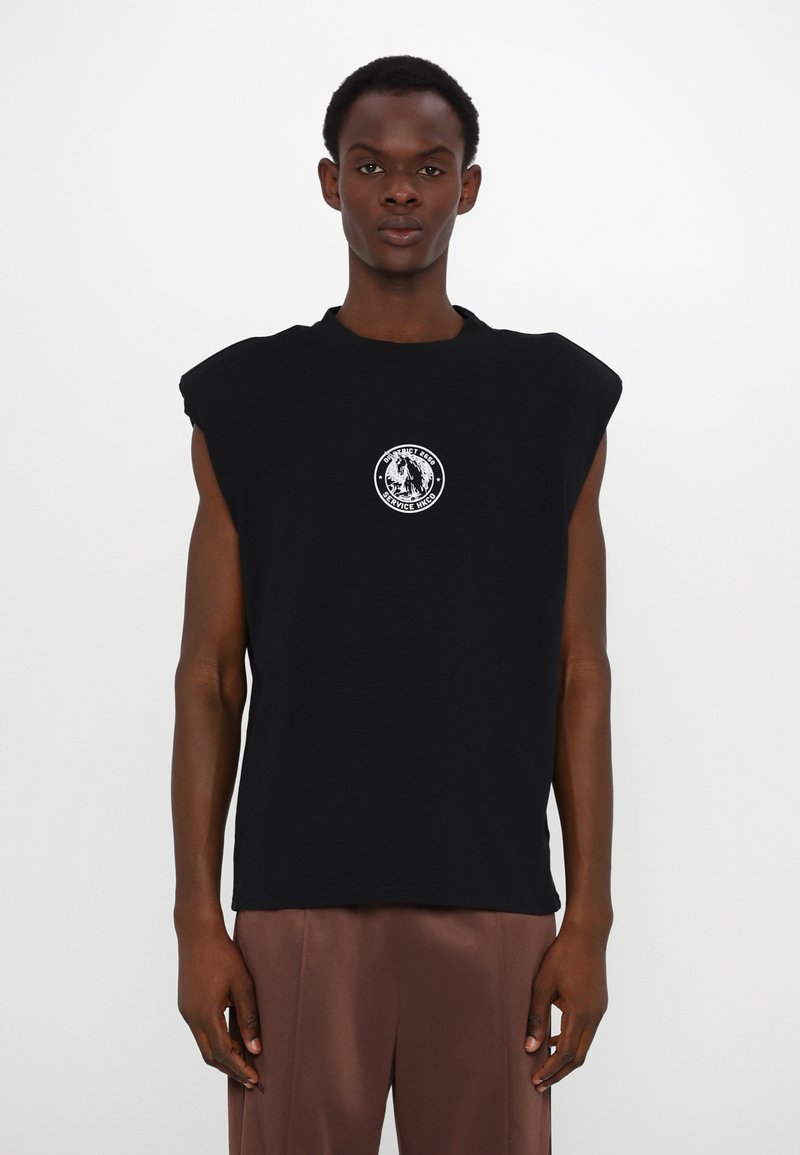 Camiseta preta sem mangas em algodão, com decote redondo e um logótipo circular no peito. Tecido suave, corte descontraído.