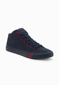 Marineblaue High-Top-Sneaker aus Canvas mit roten Ösen und Akzenten. Gummisohle mit einem kontrastierenden roten Streifen für zusätzlichen Detail.