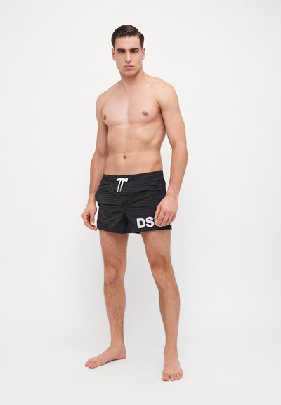 Shorts de bain noirs avec un motif texturé, dotés d'un cordon blanc et d'un bold "DS" en lettres blanches sur le côté gauche.