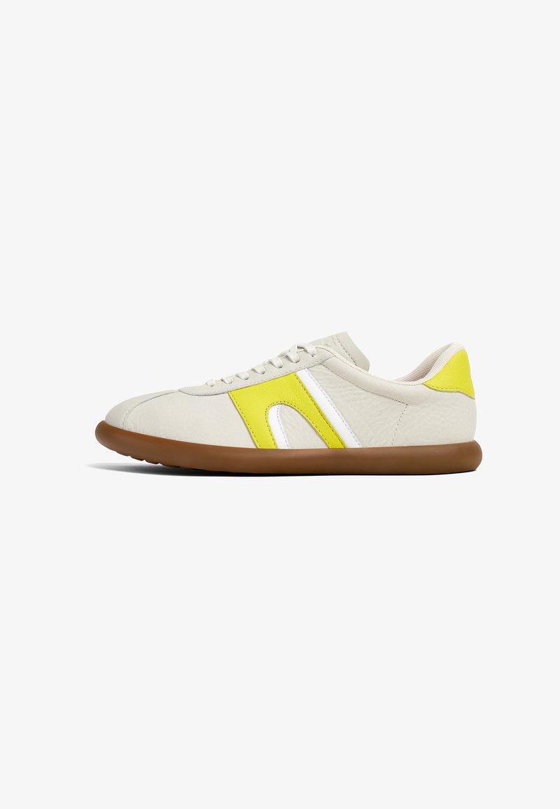 Snørebåndssneakers med en beige syntetisk overdel, gule og hvide detaljer, rund tå og en gummi brun sål. Letvægtsdesign.