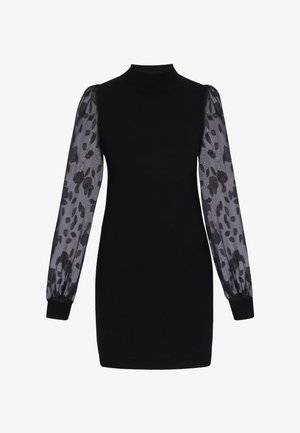 Fekete pulóverruha magas nyakkal és áttetsző, hosszú ujjakkal, fekete virágmintákkal és testhezálló mandzsettákkal.