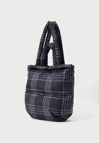 Black and gray plaid tote bag with a padded design, featuring two thick, twisted handles and a soft, quilted texture.