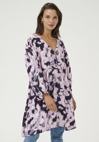 Blumenkleid in Lila, Pink und Schwarz. Verfügt über einen V-Ausschnitt, lange puffärmel und eine geraffte Taille. Weicher Stoff mit fließendem Design.