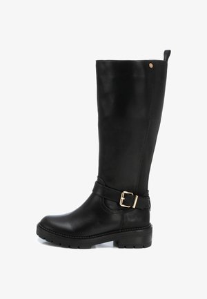 Bota alta de cuero negra con punta redonda, panel lateral texturizado y un acento de hebilla en la correa. Suela gruesa para mayor tracción.