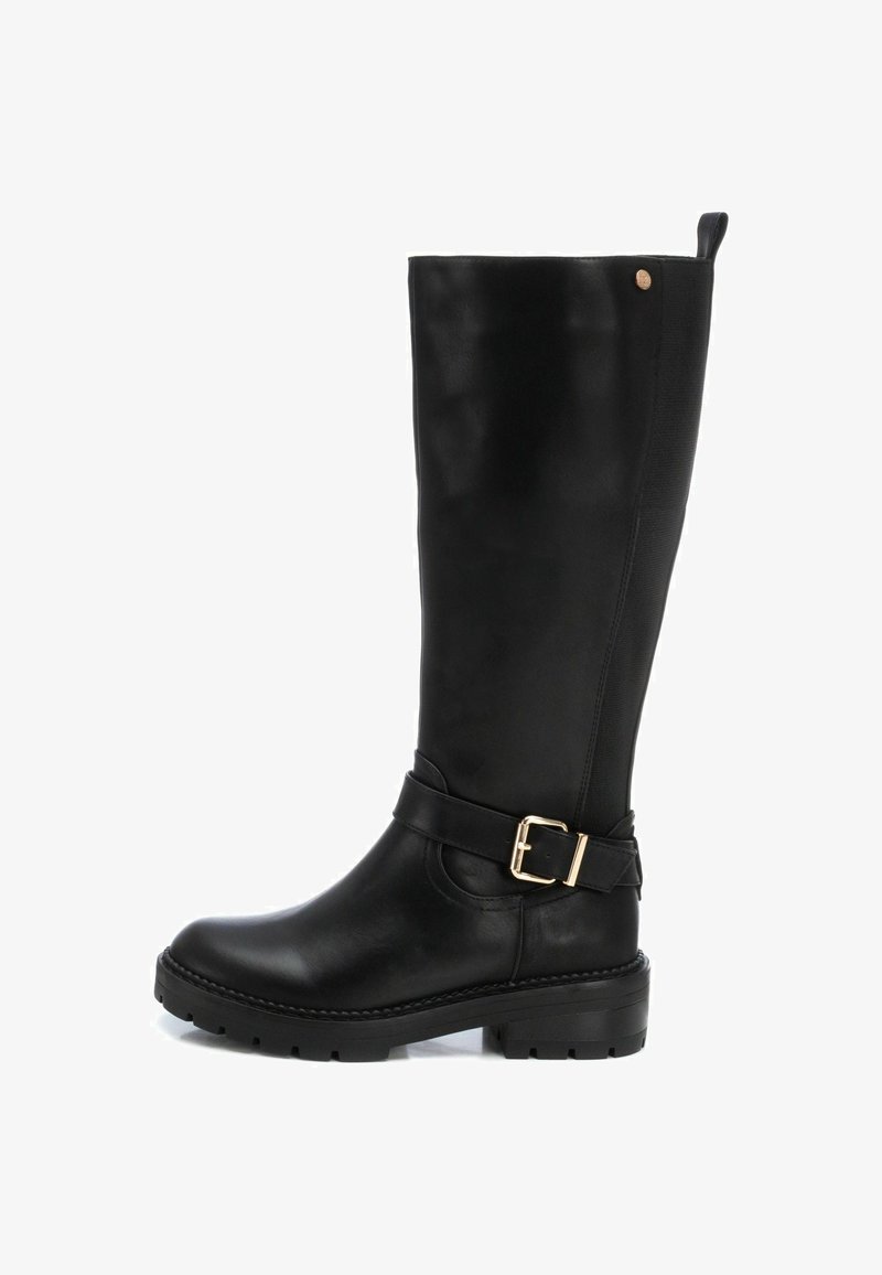 Bota alta de cuero negra con punta redonda, panel lateral texturizado y un acento de hebilla en la correa. Suela gruesa para mayor tracción.