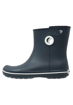 Navy blue rubber boot with a round cutout and white accents. Features a smooth texture and a rounded toe. Low ankle design.