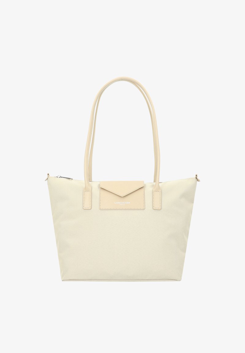 Sac en toile beige avec des accents en cuir lisse, une forme structurée, deux poignées et une petite poche à rabat à l'avant. Fermeture supérieure zippée.