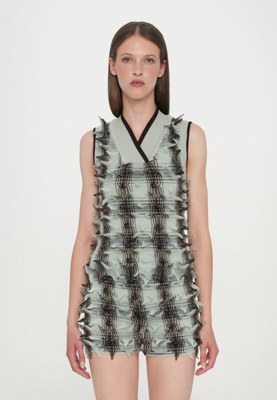 Robe sans manches en tissu vert clair, présentant des détails volants proéminents. Accentuée de rayures foncées, elle a un décolleté en V et une coupe ajustée.