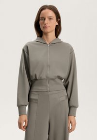Felpa grigia corta con zip frontale, cappuccio e maniche lunghe. Realizzata in tessuto liscio con finitura opaca, presenta polsini e orlo elasticizzati.