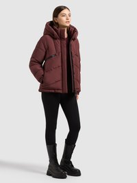 Bordo toonitud jope kapuutsiga, millel on diagonaalne õmblus ja tõmblukuga taskud. Kanditud mustade retuuside ja pits-up võitlussaabastega.