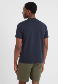 Navy blue cotton t-shirt with short sleeves and a crew neckline, worn with olive green shorts. Minimalist design, no visible patterns or graphics.