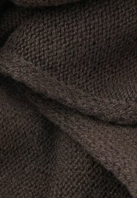 Brunt strikket stof med en tekstureret, vævet mønster og en blød, fuzzy overflade i forskellige nuancer af brunt.