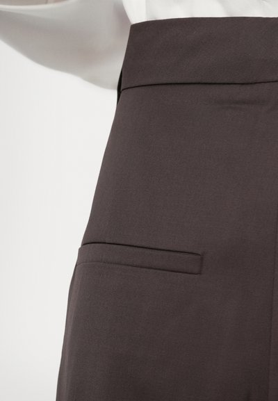 Tmavošedé elegantné nohavice vyrobené z hladkej tkaniny. Majú plochý pás a jednú zadnú vrecko. Jednoduchý, elegantný dizajn bez viditeľných vzorov.